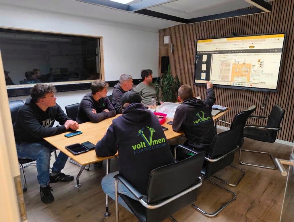 Team der Voltmen Elektrotechnik GmbH bei einer internen Schulung und Weiterbildung vor einem Monitor